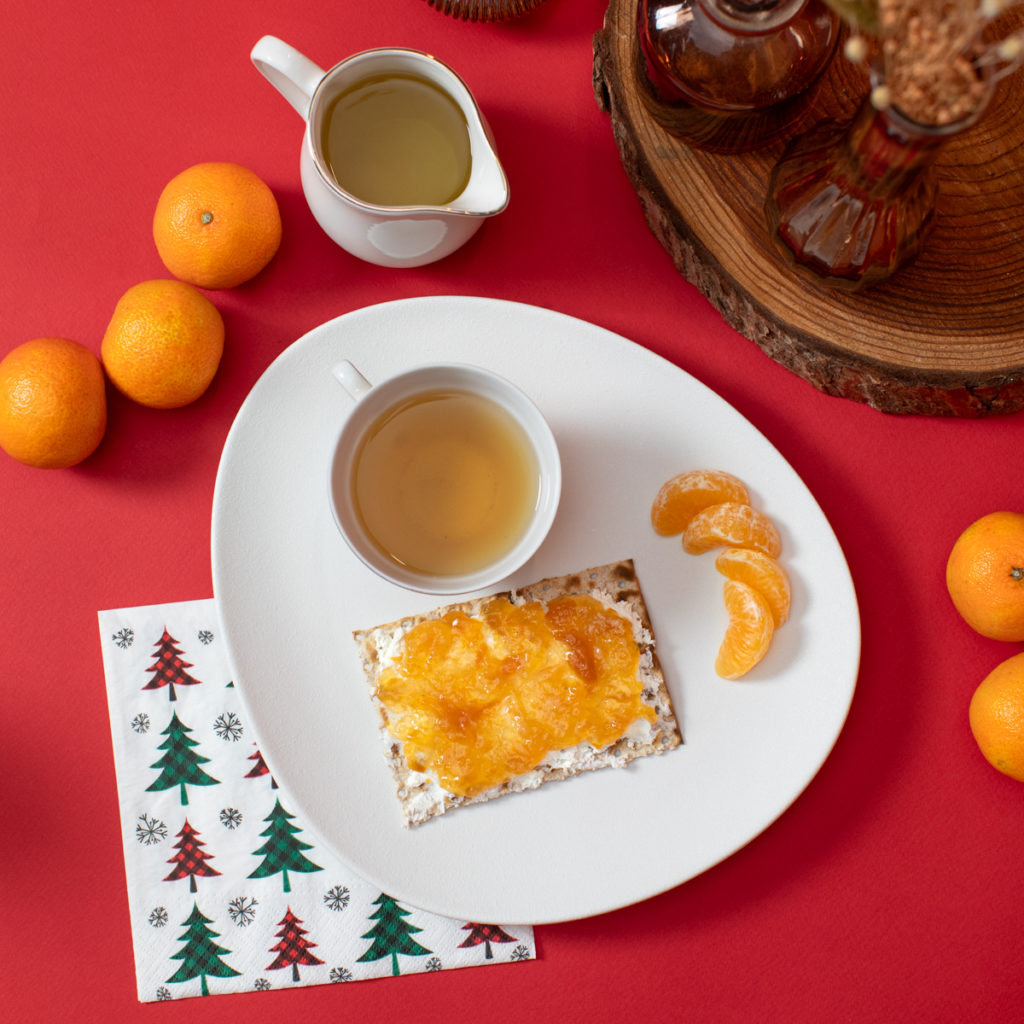 Tartine de pain azyme Heumann au fromage frais et confiture de clémentine, servie avec une boisson chaude