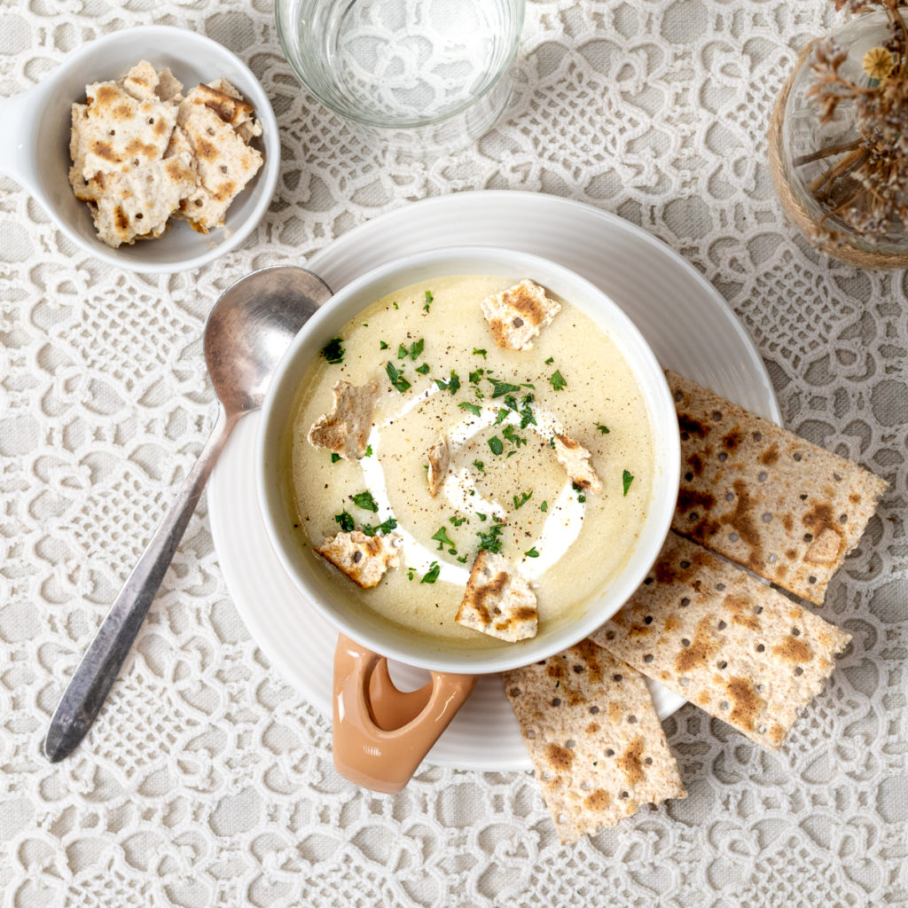 Bol de velouté de chou-fleur aux herbes servi avec morceaux de pain azyme Heumann